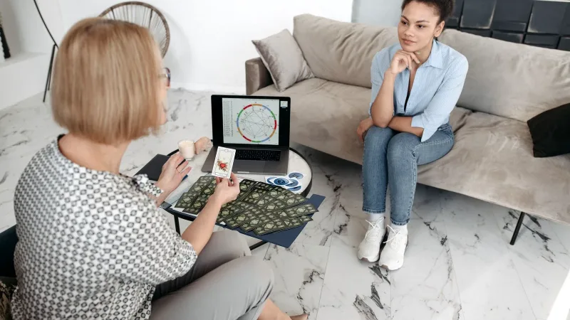 Kanepede oturup astroloji haritası üzerine sohbet eden iki kişi