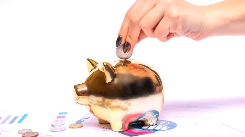 Kumbaraya para atan el ve masadaki finansal belgeler