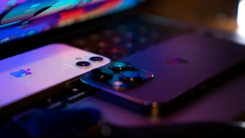Dizüstü bilgisayar klavyesi üzerinde duran iki akıllı telefon