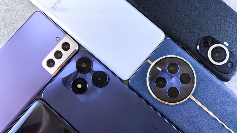 Düz bir zeminde yan yana dizilmiş farklı akıllı telefonlar